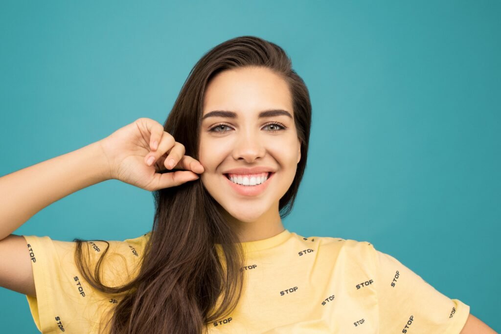 A woman smiles in our dental office during a teeth whitening consultation.