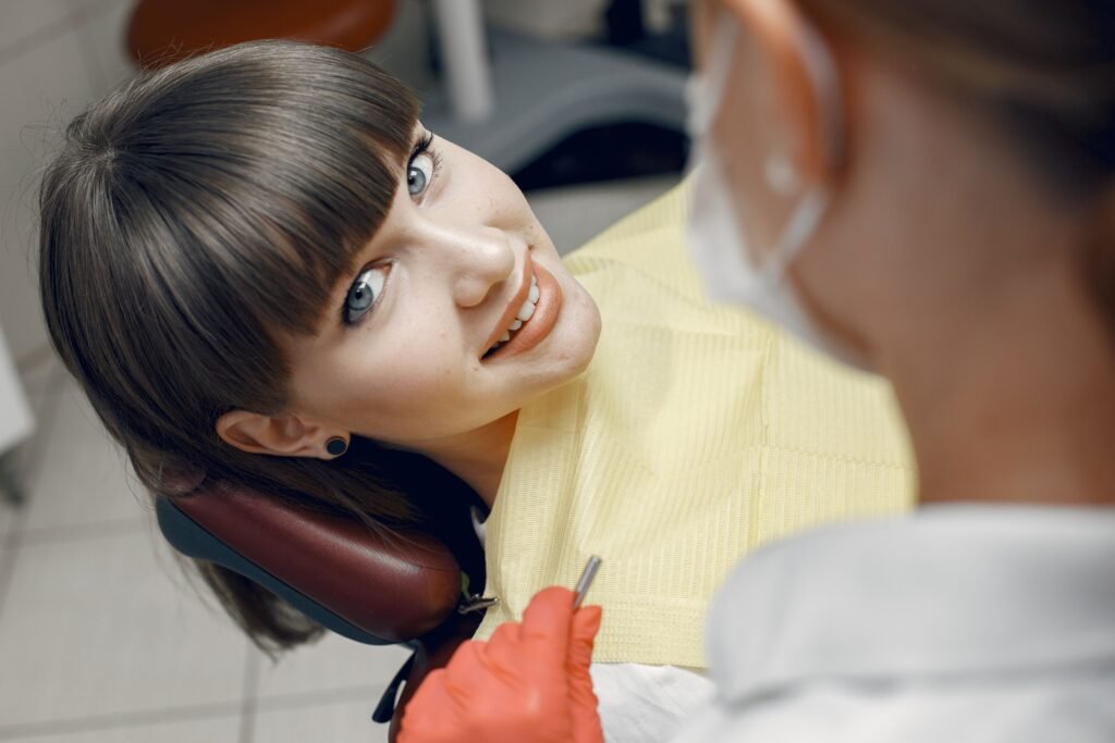 Woman smiling in the mirror while using dental floss.